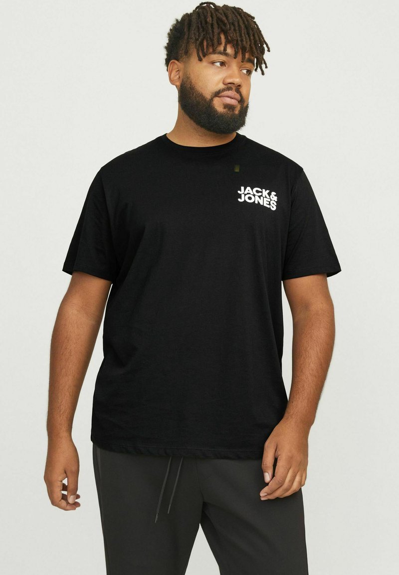 Schwarzes Baumwoll-T-Shirt mit kurzen Ärmeln, das ein weißes Logo auf der linken Brust zeigt. Der Stoff wirkt glatt und leicht.