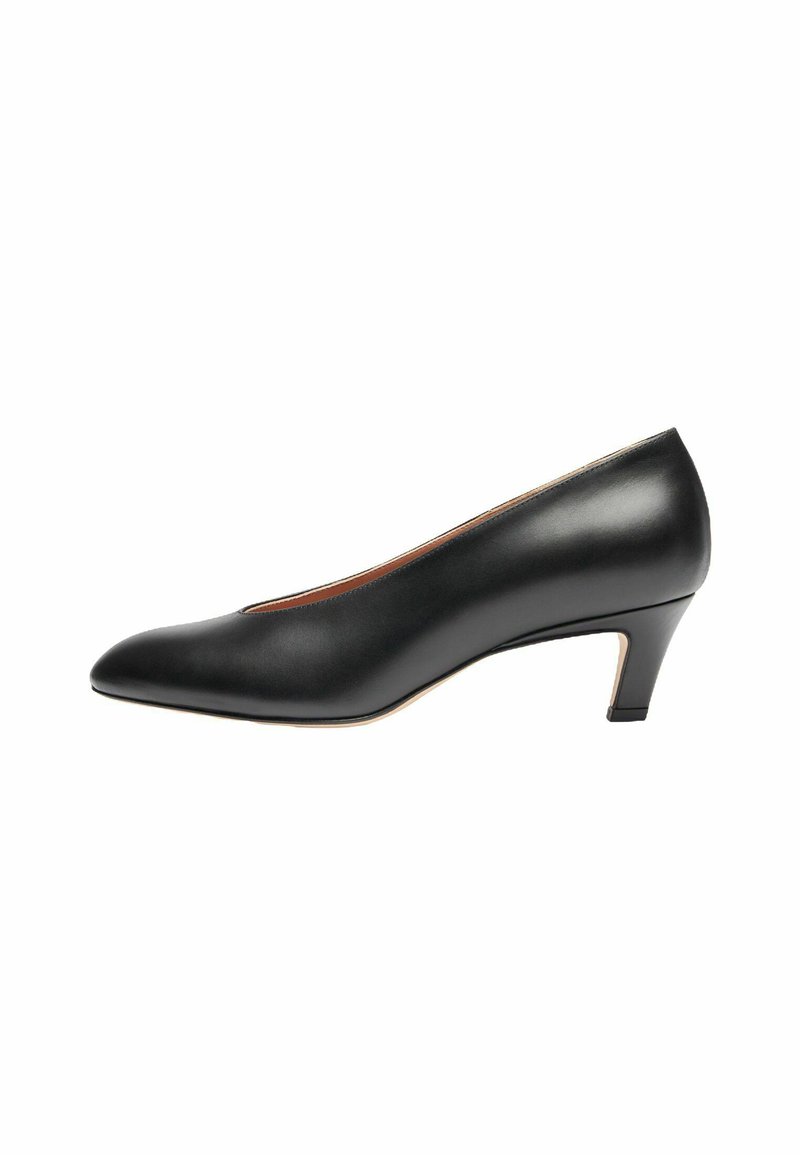 Zapato de tacón negro de cuero con punta afilada y tacón de altura media. Textura suave con un diseño minimalista y sin adornos visibles.