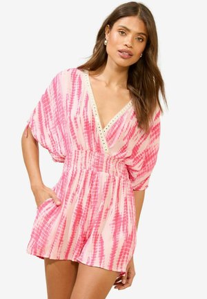 Monosuje de tiñido en rosa con un escote en V profundo, mangas anchas, cinturilla elástica y bolsillos; presenta acentos metálicos a lo largo del escote.