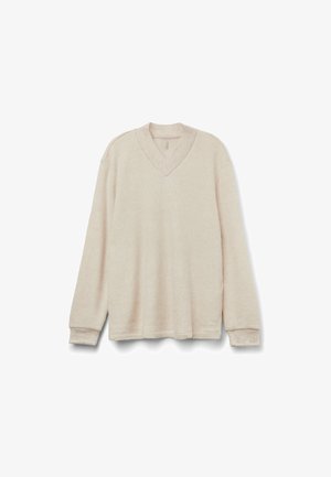 Suéter de punto beige con escote en V, mangas largas y textura acanalada. Presenta un corte relajado y detalles de costura sutiles.