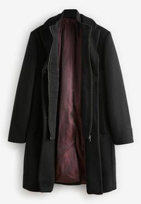 Schwarzer Wollmantel mit hohem Kragen, Reißverschluss vorne und zwei seitlichen Taschen. Das Innere ist mit einem strukturierten burgunderfarbenen Futter mit Diamantmuster ausgestattet.