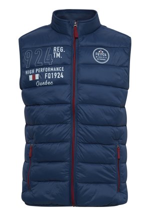 Chaleco acolchado azul marino con cuello alto, cierre frontal con cremallera y dos bolsillos con cremallera. Presenta texto bordado en blanco y acentos de logo.