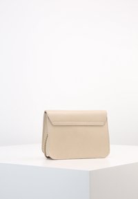 Borsa beige texturizzata con chiusura a patta e tracolla a catena. Forma rettangolare compatta con bordi lisci e design minimalista.