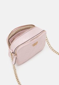 Różowa pikowana torebka na ramię z elementami w kolorze złotym, dwiema zamykanymi na zamek komorami oraz łańcuszkowym paskiem. Na przodzie znajduje się tłoczono logo.