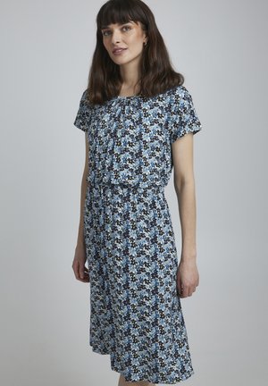 Robe à imprimé floral avec des manches courtes, un col froncé et une taille marquée. Présente un mélange de couleurs bleu, jaune et noir sur un fond clair.