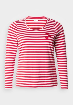 Punaste ja valgete triipudega pikad varrukad. Omab ümmargust kaelust ja kolme väikest vildist südameaktsenti rinnal. Pehme kangas.