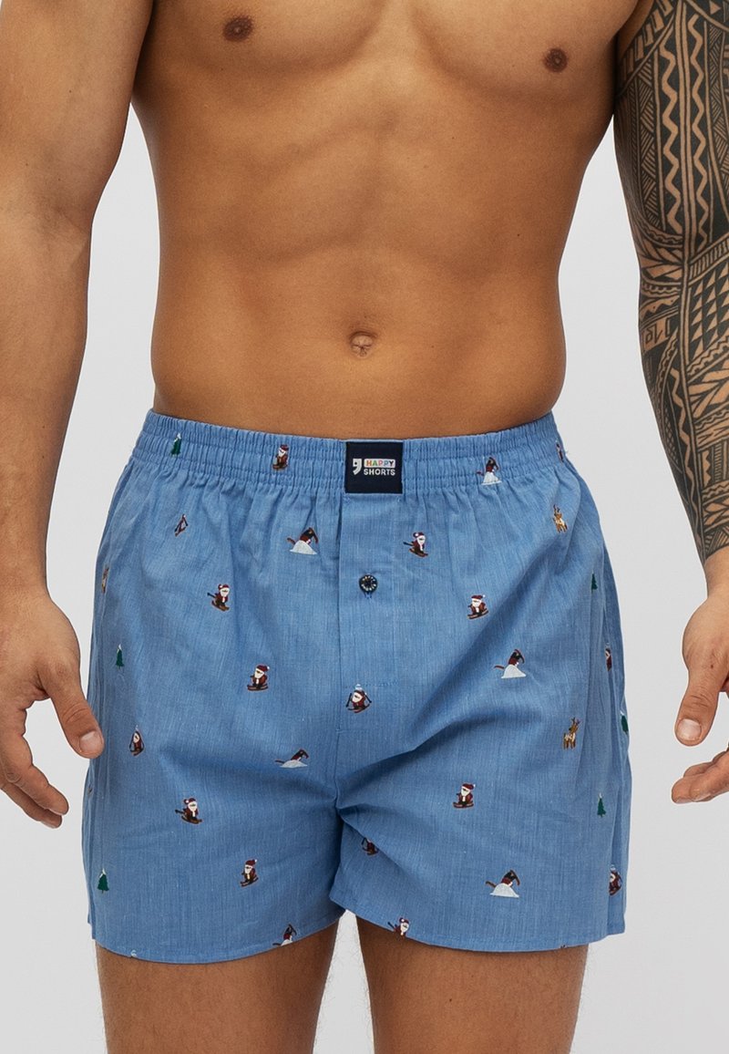 Lichtblauwe boxershorts van katoen, met kleine ski-thema patronen, een elastische tailleband en een knoopsluiting aan de voorkant.