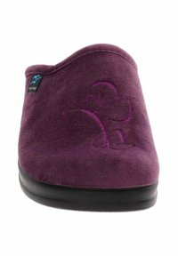 Pantofole in suede viola con forma arrotondata, texture morbida e suola in gomma nera. Presentano un design impressato e un'etichetta sul lato.