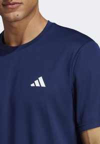 Navyblaues, kurzärmeliges Sportshirt aus atmungsaktivem Material, mit einem weißen dreieckigen Logo auf der Brust und einem Rundhalsausschnitt.
