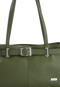 Zelená kožená taška přes rameno s texturovaným povrchem, stříbrnými kovovými doplňky, detailem s přezkou na popruhu a značkovou etiketou na boku.