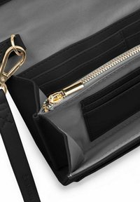 Černá peněženka z hladké kůže, s několika sloty na karty, zipovou kapsou a zlatými kovovými detaily. Interiér je podšitý šedou látkou.