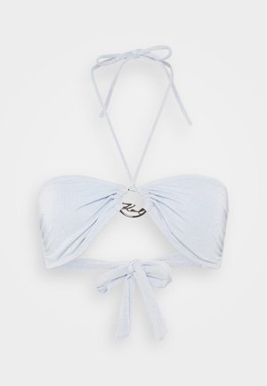 Lichtblauwe bikini top van glanzende stof, met verstelbare strikjes en een metalen versiering in het midden.