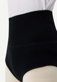 Svart ribbad högmidjad underkläder med en mjuk textur och bred elastisk band i midjan. Snittet är högt och täcker höfterna.