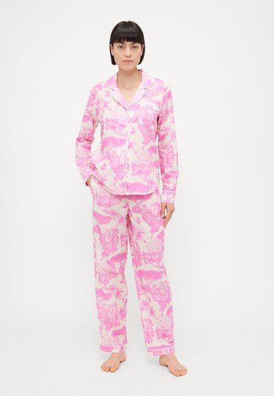 Pink pajama set featuring a button-up top with a pocket and long pants; floral and wildlife print; smooth texture, relaxed fit.