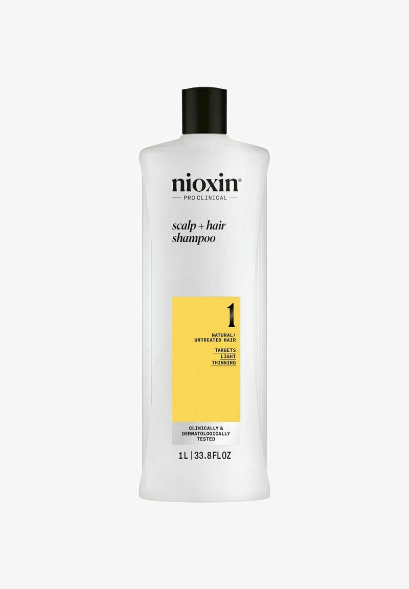 Witte plastic fles van Nioxin Pro Clinical Scalp + Hair Shampoo. Heeft een zwarte dop en een gele label met de aanduiding "1" voor natuurlijke haartypes.