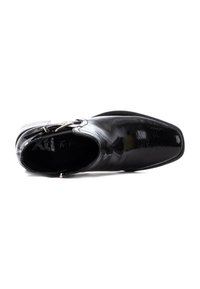 Zapato de vestir de charol negro con un diseño elegante de punta afilada, acentos en metal plateado y una superficie lisa y brillante.