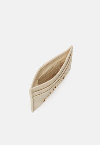 Beige textured card holder with a gold-tone hardware accent, featuring an open design and a smooth interior lining for easy access.