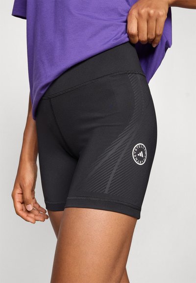 Fekete atlétikai rövidnadrág oldalán csíkos mintázattal, magas derékrésszel és egy logófolttal a combon. Rugalmas, sima anyagból készült.