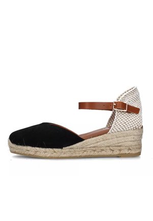 Espadrilles con zeppa in suede nero, cinturino alla caviglia in pelle color cuoio, tessuto beige intrecciato sul retro e suola in juta texture.