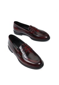 Ciemnoczerwone skórzane loafersy o gładkim wykończeniu, z dekoracyjnym paskiem i lekko podniesionymi brzegami na palcach. Gumowa podeszwa zapewniająca przyczepność.