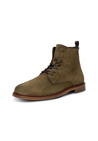 Stivaletti alla caviglia in suede verde oliva con punta arrotondata, lacci in pelle e suola in pelle marrone. Presentano un'etichetta per una facile calzata.