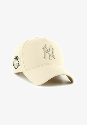 Beige baseball cap with embroidered NY logo and black patch on the side. Designed with a curved brim and textured fabric for durability.