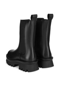 Czarne skórzane botki za kostkę z elastycznymi panelami po bokach, zaokrąglonym noskiem oraz masywną gumową podeszwą z wyraźnym wzorem bieżnika.