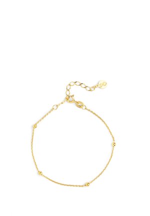 Pulsera de cadena de oro con pequeñas cuentas redondas. Presenta un cierre de broche y longitud ajustable con una cadena de extensión. Textura suave.