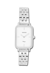 Montre rectangulaire en argent avec un cadran blanc, des marques minimales et un bracelet en maillons métalliques. Présente une couronne sur le côté pour les réglages.