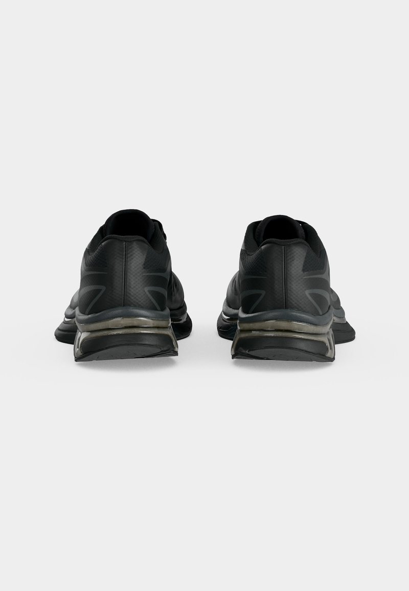 Pair of black athletic shoes shown from the back, featuring cushioned soles and subtle design accents on a white background.