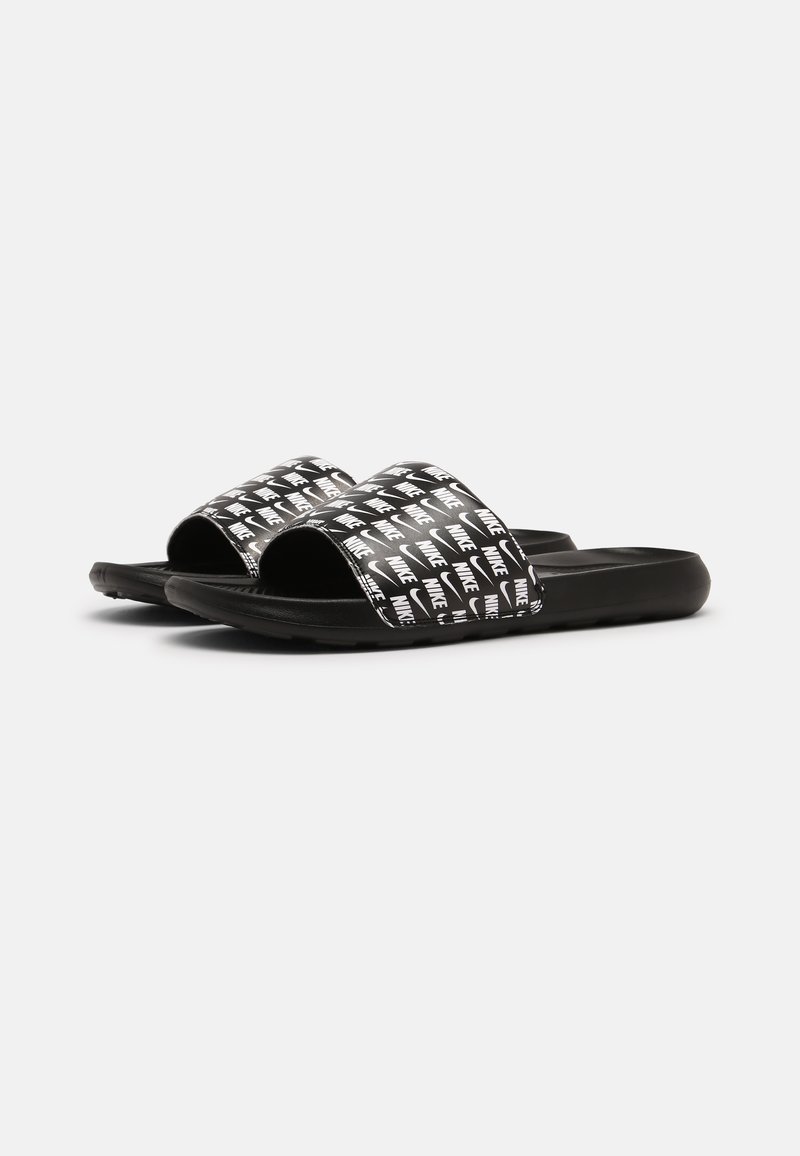 Chanclas negras con tiras anchas que presentan un patrón repetitivo del logo de Nike en blanco. Suela de goma suave para mayor comodidad y fácil uso.