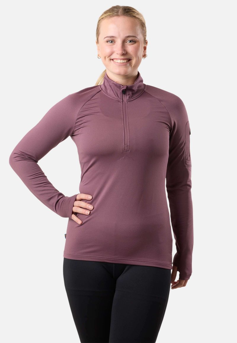 Top a maniche lunghe con zip in tessuto mauve, dal design aderente, con fori per il pollice, texture liscia e dettagli di cucitura discreti.
