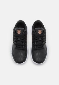 Sneakers atletici neri con tomaia sintetica testurizzata, caratterizzati da un design a strisce rialzate, suole bianche e logo K-Swiss sulla linguetta.