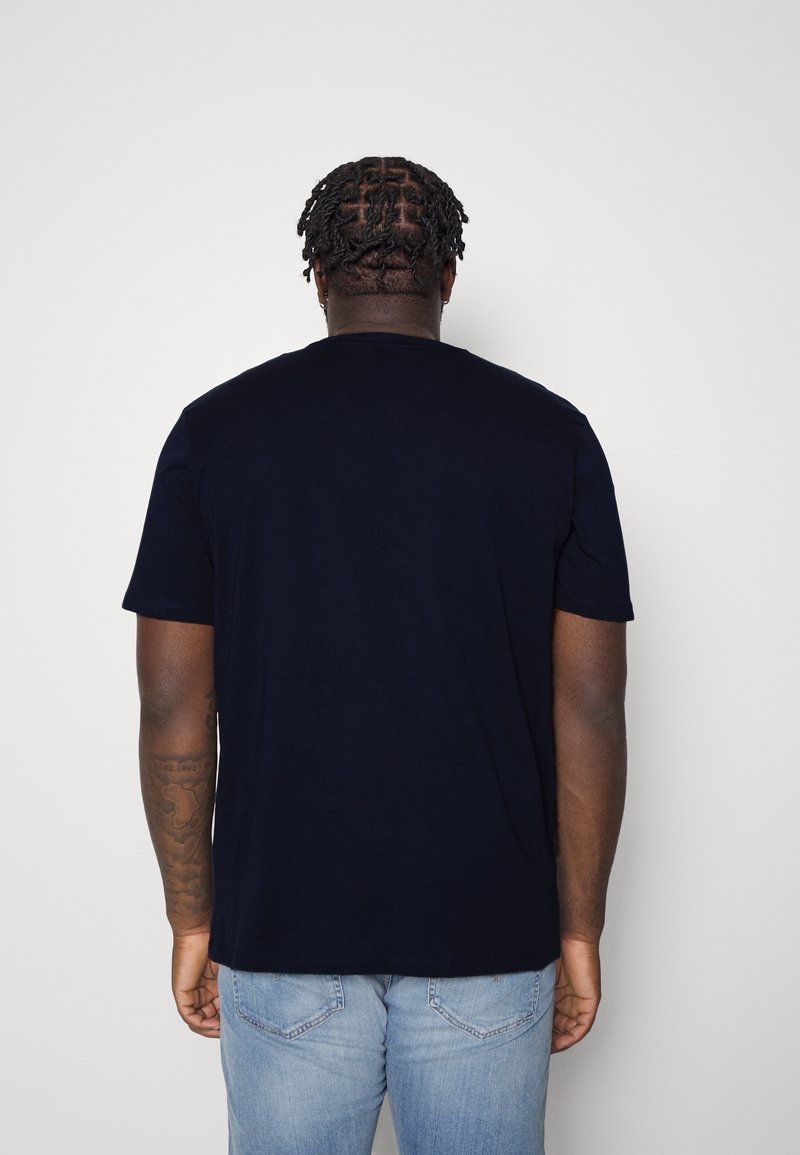 Granatowa bawełniana koszulka z krótkim rękawem, okrągłym dekoltem i luźnym krojem. Posiada gładką fakturę oraz prosty design bez widocznych logo czy wzorów.