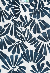 Tessuto bianco con un motivo a conchiglie blu navy. Presenta un design a V con cuciture a contrasto. Texture leggera e traspirante.