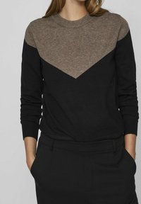 Maglione nero con collo rotondo e maniche lunghe. La parte superiore presenta un motivo triangolare marrone. Realizzato in un tessuto morbido e strutturato.