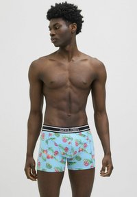 Boxer blu con motivo ananas e foglie, caratterizzati da un elastico nero con il logo "JACK & JONES". Realizzati in un materiale morbido ed elastico.