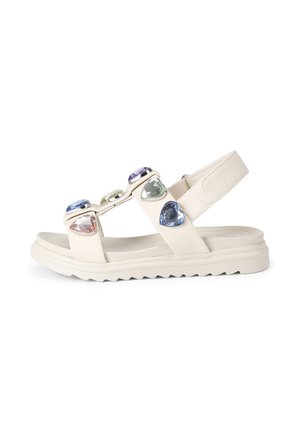White sandal with adjustable back strap and colorful heart-shaped gems on the straps over the footbed and sole.