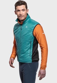 Leichtgewichtige tealfarbene Weste mit schwarzen und orangefarbenen Akzenten. Gepolstertes Design mit hohem Kragen und seitlichen Taschen. Texturiertes, orangefarbenes Langarmhemd darunter.
