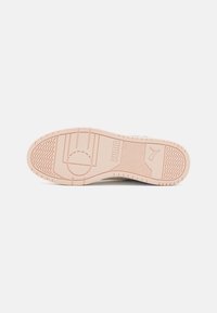 Sole di scarpa PUMA realizzata in un materiale gommoso di un rosa chiaro, caratterizzata da un motivo testurizzato e dettagli con logo. Sezioni lisce e scanalature per una migliore aderenza.