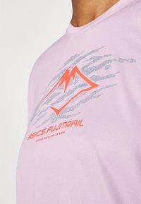 Vaaleanpunainen lyhythihainen paita, jossa on teksturoitu kuvio, oranssi ja hopea grafiikka "ASICS FUJITRAIL" -tekstillä, pyöreä pääntie.