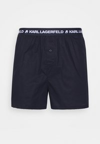Námornícky modré boxerky vyrobené z bavlny s predným gombíkom, elastickým pásom s bielym logom "KARL LAGERFELD". Jednoduchý, klasický dizajn.