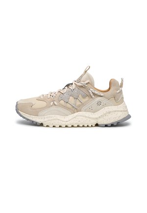 Sneaker sportiva beige e grigia con suola strutturata, design con lacci, linguette sulla lingua e sul tallone, e pannelli stratificati in tessuto e suede.