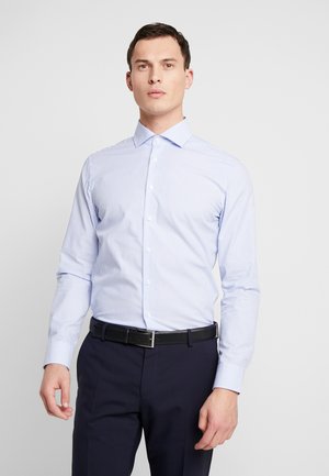 Hellblau-weiße gestreifte Hemdbluse mit Button-down-Kragen, langen Ärmeln und schlanker Passform, kombiniert mit dunklen Hosen und einem schwarzen Gürtel.