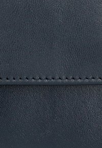 Skórzany portfel w ciemnym granacie z teksturowaną powierzchnią, widocznym przeszyciem na krawędzi oraz czystym, eleganckim designem.