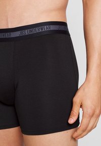 Sorte stretch bomulds boxershorts med en blød elastisk talje, med "JBS UNDERWEAR" logo i grå langs bæltet.