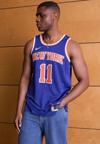 New York Knicks basketballtrøje, blå med orange accenter, med "NEW YORK" og nummer "11," lavet af åndbart mesh-stof.