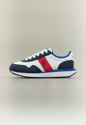 Sportske tenisice u mornarsko plavoj, bijeloj i crvenoj boji. Izrađene su od kože i sintetičkih materijala, imaju zaobljeni vrh i kontrastne pruge s detaljem logotipa.