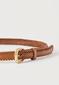 Πλεκτή καφέ δερμάτινη ζώνη με αγκράφα από μέταλλο σε χρυσό τόνο και διακριτικό λογότυπο, που παρουσιάζει υφή σχεδίου και ευέλικτη κατασκευή.