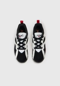 Αθλητικά πα πούτσια σε ασπρόμαυρο με υφασμάτινη υφή, πάνελ από δίχτυ και κόκκινη λεπτομέρεια στη φτέρνα. Διαθέτουν μαύρα κορδόνια και λογότυπο.